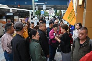 一名中国旅行社的导游11月17日在东京街头向随团的中国游客分发免税店传单。（法新社）