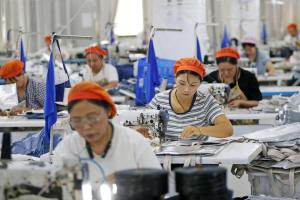 图为8月21日在中国安徽省临涣镇的一家箱包制造厂，车间里一群不同年龄层的妇女在工作。（法新社）